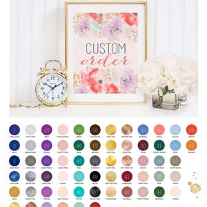 May include: A framed print with watercolor floral art and the words "CUSTOM ORDER" in a script font. A gold alarm clock and a vase of white flowers are next to the print. A color chart is below.