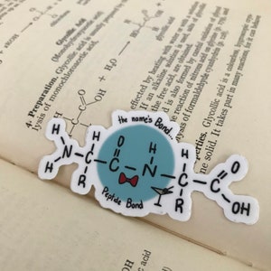May include: A sticker with a cartoon illustration of a peptide bond, a type of chemical bond that links amino acids together to form proteins. The sticker is blue with a red bow and the text "the name's Bond..." and "Peptide Bond".