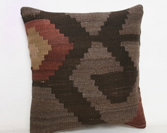 May include: A square throw pillow with a geometric pattern in shades of brown, beige, and red. The pillow is made of woven fabric and has a soft, textured surface.