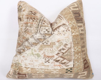 May include: A beige and brown patterned throw pillow with a geometric design. The pillow is made from a soft, woven fabric and has a subtle sheen.