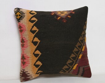 May include: Black and brown patterned throw pillow with a geometric design. The pillow is made of woven fabric and has a fringe border.