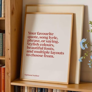 May include: A framed print with a white background and red text. The text reads "Your favourite quote, song lyric, phrase, or saying. Stylish colours, beautiful fonts, and multiple layouts to choose from." The text "Optional Author" is printed below the main text.