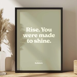 May include: A framed print with a light green background and white text that reads "Rise. You were made to shine." The text is in a retro font style. The bottom of the print has the word "Kollektiv" in white text.