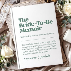 May include: A white hardback book titled The Bride-To-Be Memoir with dark green text. The cover includes a phonetic pronunciation, a definition of the title, and the text A memoir by: Charlotte in a script font, centred on the front cover.