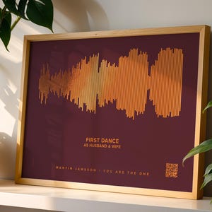 May include: A framed print featuring a soundwave design in shades of gold and orange against a deep burgundy background. The text "FIRST DANCE AS HUSBAND & WIFE" is displayed, along with names and the phrase "YOU ARE THE ONE".