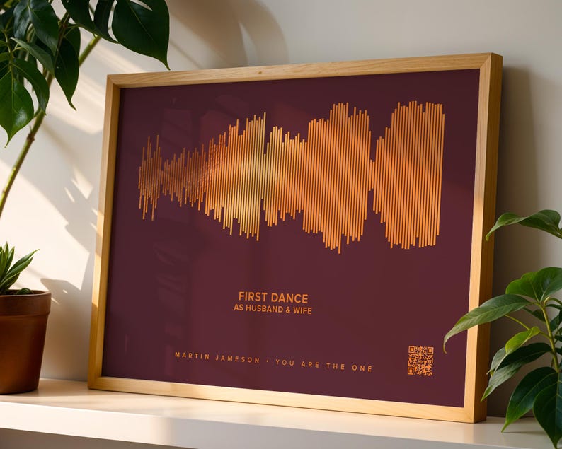 May include: A framed print featuring a soundwave design in shades of gold and orange against a deep burgundy background. The text "FIRST DANCE AS HUSBAND & WIFE" is displayed, along with names and the phrase "YOU ARE THE ONE".