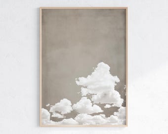 May include: A framed print of a minimalist abstract art piece featuring white clouds against a light brown background.
