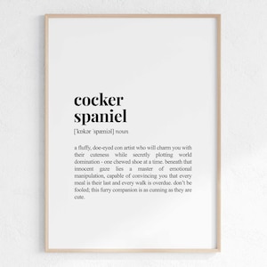 Op de afbeelding: Een zwart-witte printbare kunstprint met de definitie van een cocker spaniel. De definitie luidt: "Een pluche, ree-ogen con-artist die je zal betoveren met zijn schattigheid terwijl hij stiekem de wereldheerschappij plant - een gekauwde schoen tegelijk, onder die onschuldige blik schuilt een meester in emotionele manipulatie, die je kan overtuigen dat elke maaltijd zijn laatste is en elke wandeling te laat is, laat je niet voor de gek houden; deze harige metgezel is net zo sluw als hij schattig is."