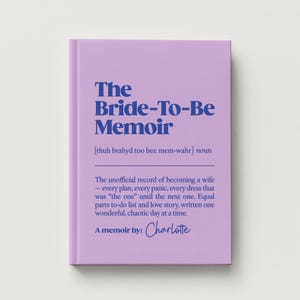 May include: A light purple book titled The Bride-To-Be Memoir with dark blue text. The cover includes a phonetic pronunciation, the noun definition, and the phrase A memoir by: Charlotte in a script font, describing a record of becoming a wife.