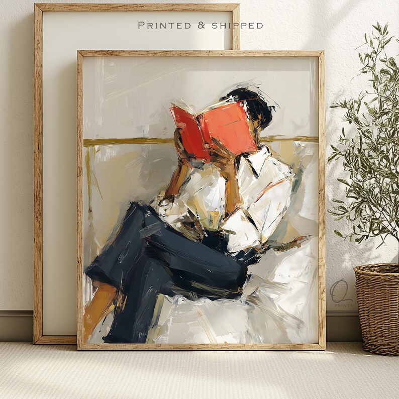 May include: Abstract art print of a person reading a book. The figure is wearing a white shirt and dark blue pants, with a bright orange book. The artwork is in a wooden frame, with the text "PRINTED & SHIPPED" at the top.