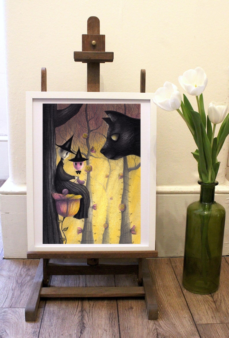 May include: A framed illustration of two witches sitting on a flower in a forest with a black cat looking at them. The witches are wearing black hats and dresses. The forest is filled with yellow and pink flowers.