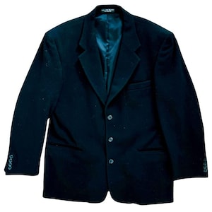 Könnte beinhalten: Ein dunkelblauer Blazer mit einreihiger Knopfleiste und drei Knöpfen. Der Blazer hat einen Schalkragen und zwei Pattentaschen.