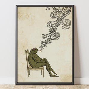 Könnte beinhalten: Gerahmter Kunstdruck mit einer entspannten Froschfigur, die eine Zigarette raucht. Der Frosch, in Grüntönen, sitzt auf einem Holzstuhl, mit aufsteigendem Rauch. Der Hintergrund hat eine Vintage-Papierstruktur.