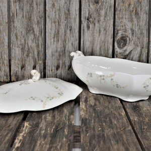 Side view with the lid off, of this beautiful casserole dish with the blue flowers and golden stems. Also showing the gold trim on the handles.