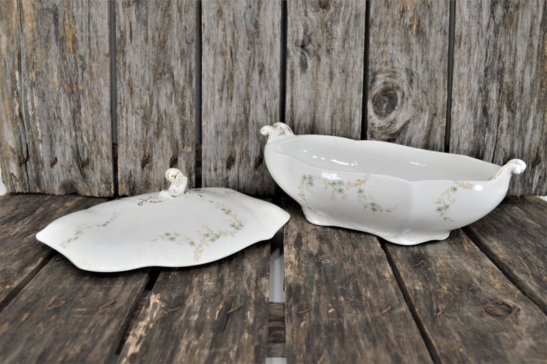 Side view with the lid off, of this beautiful casserole dish with the blue flowers and golden stems. Also showing the gold trim on the handles.