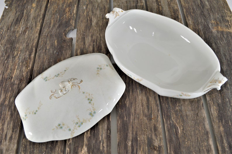 Top view with the lid off, of this beautiful casserole dish with the blue flowers and golden stems. Also showing the gold trim on the handles.