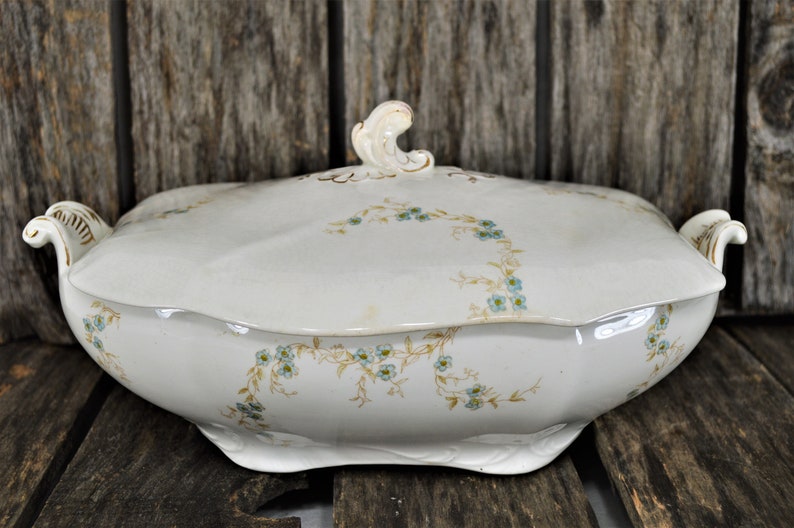 Side view of this beautiful casserole dish with the blue flowers and golden stems. Also showing the gold trim on the handles.
