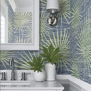 May include: A white bathroom vanity with a white countertop and a silver faucet. The wall behind the vanity is covered in blue and green wallpaper with a palm leaf pattern.