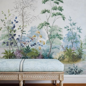 May include: A light blue upholstered bench with a detailed, carved wooden frame. The bench sits in front of a mural depicting a serene landscape with trees, birds, and foliage in shades of green, blue, and purple. The bench has a length of approximately 60 inches.