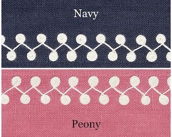 May include: Close-up of two fabric swatches with white embroidered trim. The top swatch is navy blue and the bottom swatch is a light pink color. The text "Navy" is printed on the top swatch and the text "Peony" is printed on the bottom swatch.