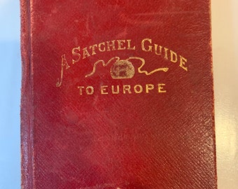 May include: A red leather-bound book with gold lettering that reads "A Satchel Guide to Europe".