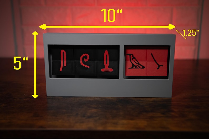 May include: A gray wooden box with a red and black design. The box is 10 inches wide, 5 inches tall, and 1.25 inches deep. The box has a hinged lid and is made of wood.
