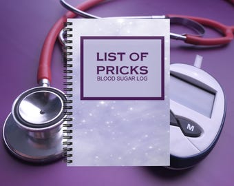 May include: A spiral-bound notebook with a light purple, starry background featuring the text LIST OF PRICKS BLOOD SUGAR LOG in a dark purple frame. The notebook is positioned between a red stethoscope and a white blood glucose monitor.