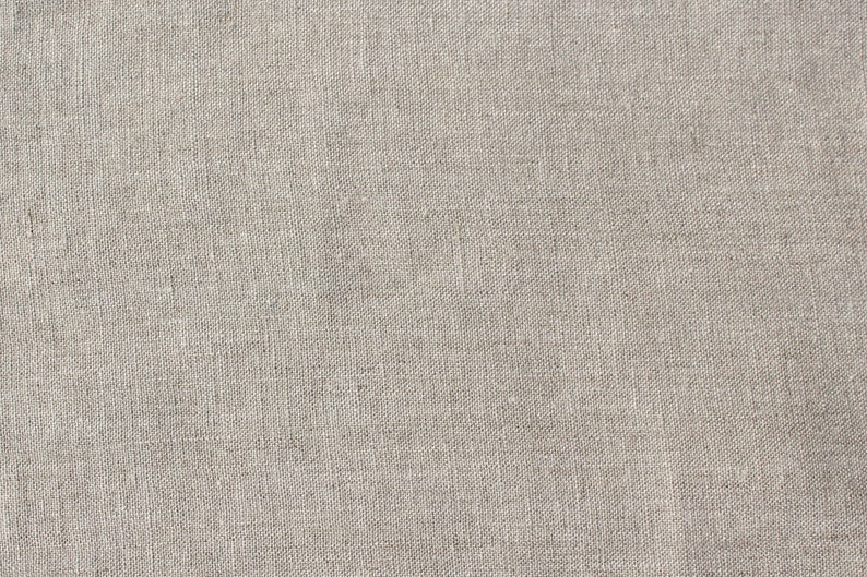 May include: A close-up of a plain, off-white canvas texture. The fabric has a subtle woven pattern.
