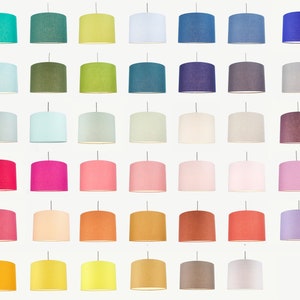 May include: A collection of 40 fabric lampshades in a variety of colours, including teal, green, blue, pink, orange, yellow, and grey. The lampshades are all the same size and shape, and they are arranged in a grid pattern.