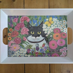 May include: White serving tray with a black and white cat with a bell collar surrounded by colorful flowers. The tray has a floral design and the text "Susan  Ruber  Cornwall" is printed on the bottom right corner.