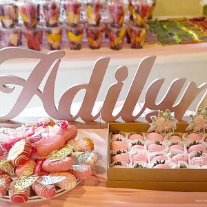 Personalized name sign in rose gold glitter finish at candy buffet table, mis quince party decor