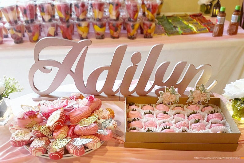 Personalized name sign in rose gold glitter finish at candy buffet table, mis quince party decor
