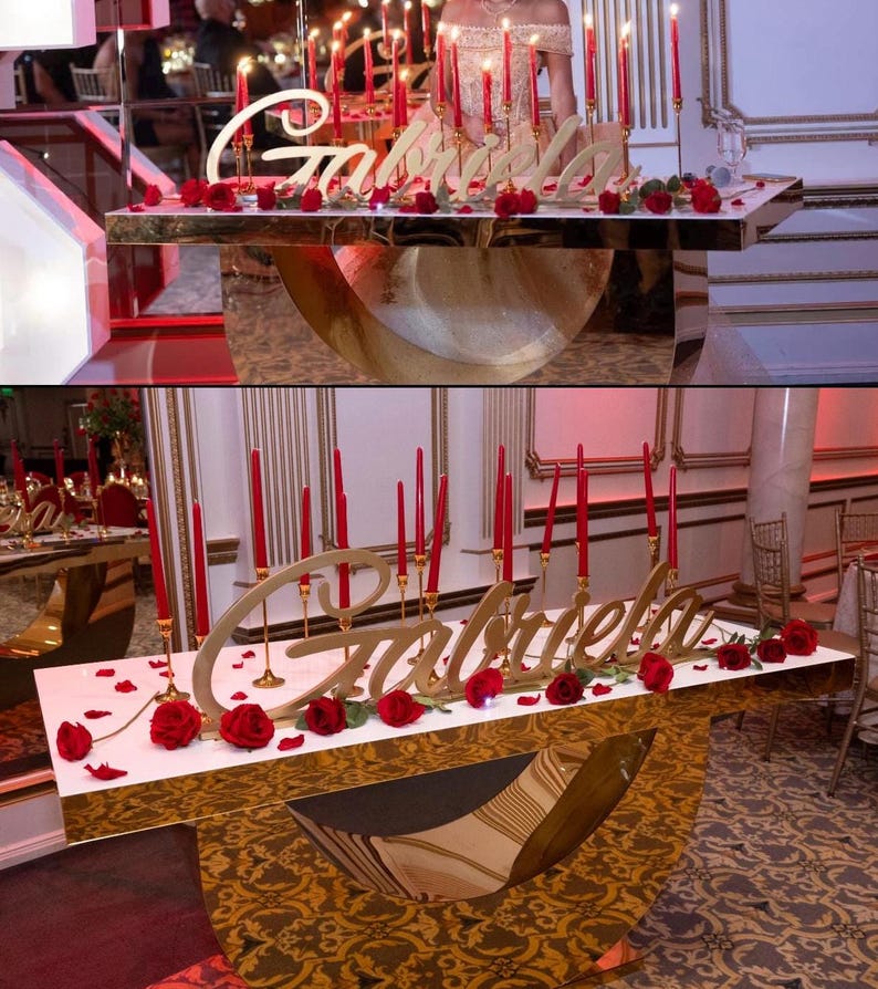 Custom wooden name sign in red glitter finish on decorated table, glamorous Quinceañera gift centerpiece