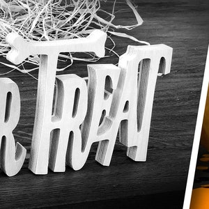 May include: White wooden letters spelling "Trick or Treat" on a dark wood background. A carved pumpkin and black spiderweb with a black chalkboard sign that says "Custom Saying" are on an orange background.