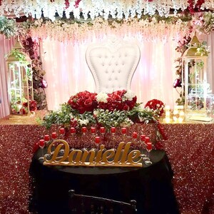 ustom wooden name sign at pink and red rose decorated Quinceañera sweetheart table centerpiece