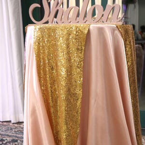 Custom wooden name sign in gold finish on sequin tablecloth, Quinceañera gift table centerpiece