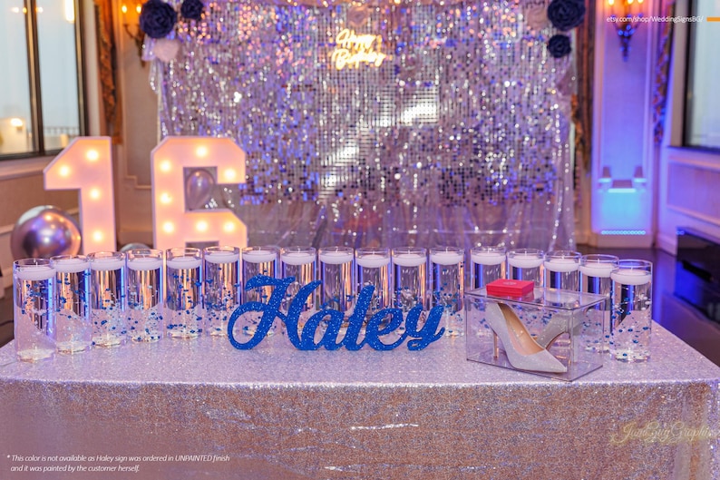 Custom wooden name sign in silver glitter finish on illuminated table, Quinceañera birthday gift decor