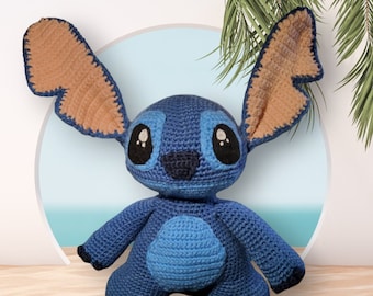 May include: A blue and brown crocheted plush toy resembling Stitch from the Disney movie Lilo & Stitch. The toy has large, round eyes, a small nose, and a wide smile.