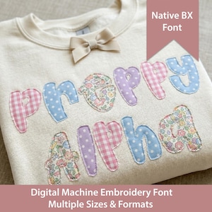 Puede incluir: Sudadera color crema con la palabra "PREPPY ALPHABET" aplicada en varias telas estampadas, incluyendo cuadros y estampados florales. Un pequeño lazo está sujeto en el escote. También se ve el texto "Native BX Font" y "Digital Machine Embroidery Font".
