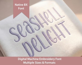 May include: A white fabric surface featuring the purple embroidered text SEASHELL DELIGHT in a cursive font. A pink banner at the top left displays the text Native BX Font, and a pink banner at the bottom displays Digital Machine Embroidery Font.