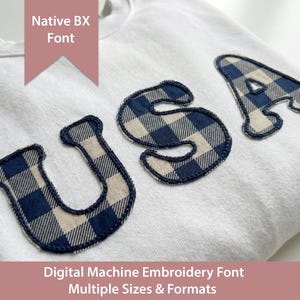 Puede incluir: Una sudadera blanca con las letras "USA" aplicadas en un patrón de cuadros azul y crema. La sudadera tiene cuello redondo. La imagen también incluye el texto "Native BX Font" y "Digital Machine Embroidery Font Multiple Sizes & Formats."