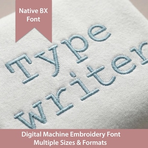 May include: A light-colored fabric featuring blue machine-embroidered text that reads Type Writer. A pink banner at the top displays the text Native BX Font, and a pink banner at the bottom reads Digital Machine Embroidery Font Multiple Sizes & Formats.