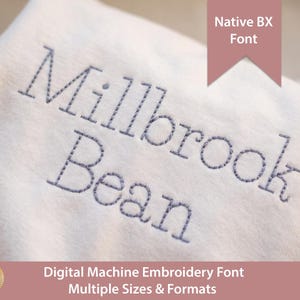 May include: A white fabric surface featuring the dark grey embroidered text Millbrook Bean in a simple sans-serif font. A pink banner at the top right displays the text Native BX Font, and a bottom pink banner displays Digital Machine Embroidery Font.