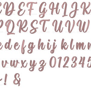 May include: A full alphabet and number set in a flowing, cursive script. The letters and numbers are in a soft, muted rose colour, with a slight shadow effect. Includes uppercase, lowercase, numbers, and symbols.
