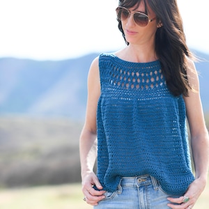 May include: A blue crochet top with a lacy neckline and sleeveless design. The top is worn with light blue jeans.