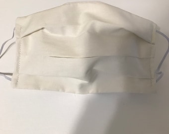 May include: A white cotton face mask with pleats. The mask has elastic ear loops.