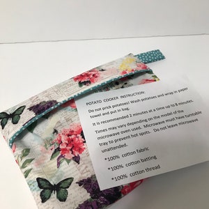 Puede incluir: Un cocedor de patatas de tela con estampado floral con instrucciones de uso. Las instrucciones incluyen lavar las patatas, envolverlas en una toalla de papel y cocinarlas en el microondas durante 2 minutos cada vez, hasta un máximo de 8 minutos. Las instrucciones también indican que el microondas debe tener un plato giratorio para evitar puntos calientes y que el microondas no debe dejarse desatendido. La tela está hecha de 100% algodón.