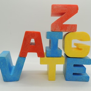 May include: A set of colorful foam alphabet blocks spelling out the word "VINTAGE". The blocks are blue, yellow, and red.