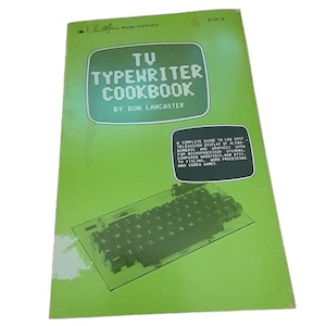 May include: A vintage book titled "TV Typewriter Cookbook" by Don Lancaster. The cover is green with white text and a graphic of a keyboard. The book is a guide to low-cost television display of alphanumeric and graphics data.