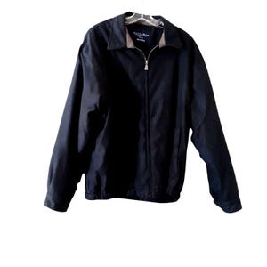 以下が含まれることがあります： スタンドカラーの黒いジップアップジャケット。ジャケットの左胸には「Hallsman」というブランドラベルが付いています。